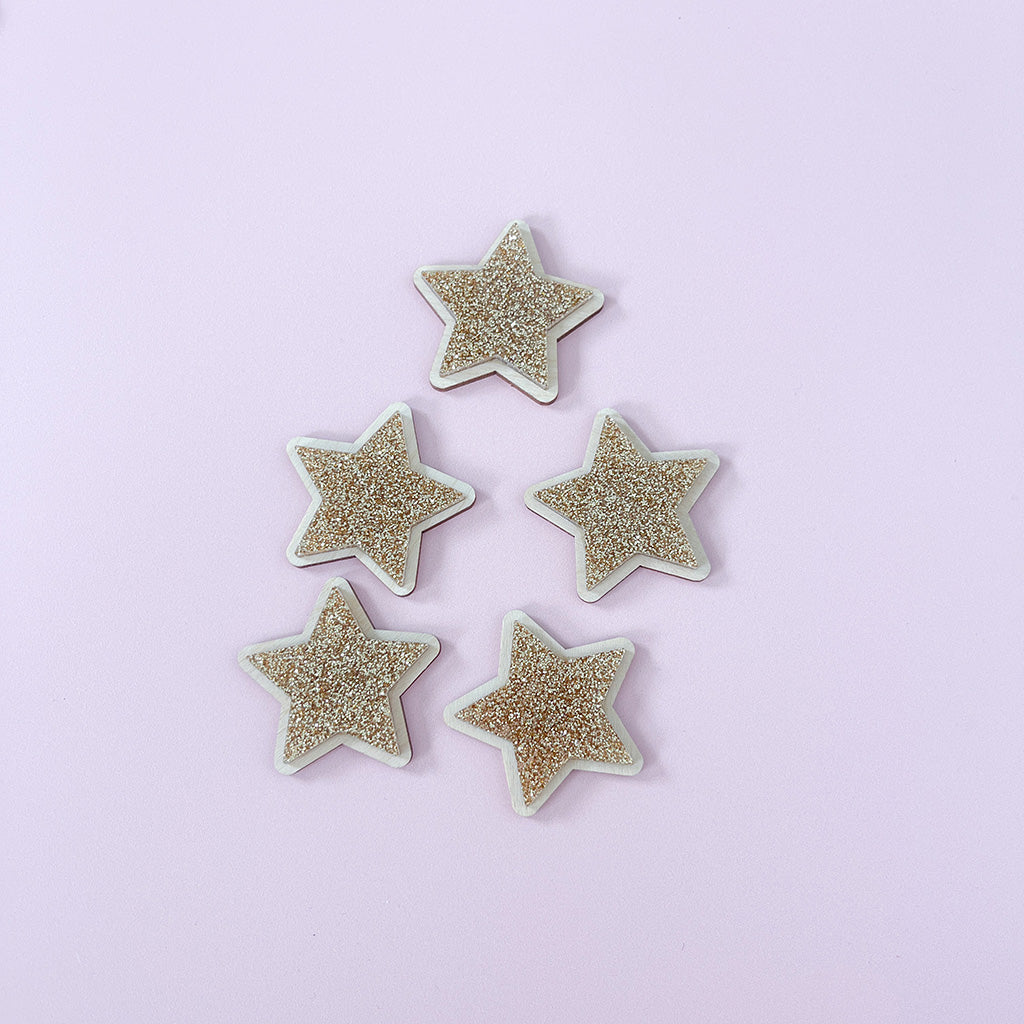 Gold glitter star wall decor displayed beside a framed children's print