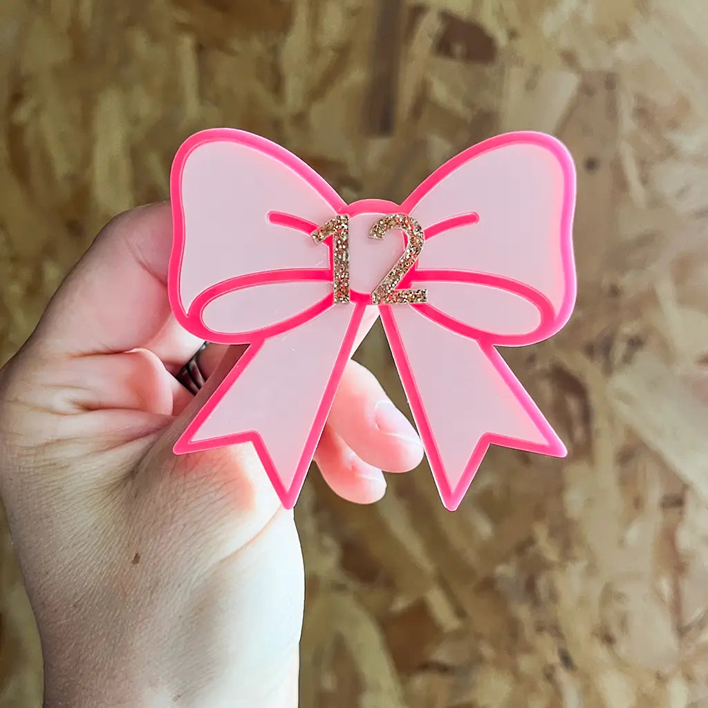Pink bow birthday badge personalised with a gold glitter age number
