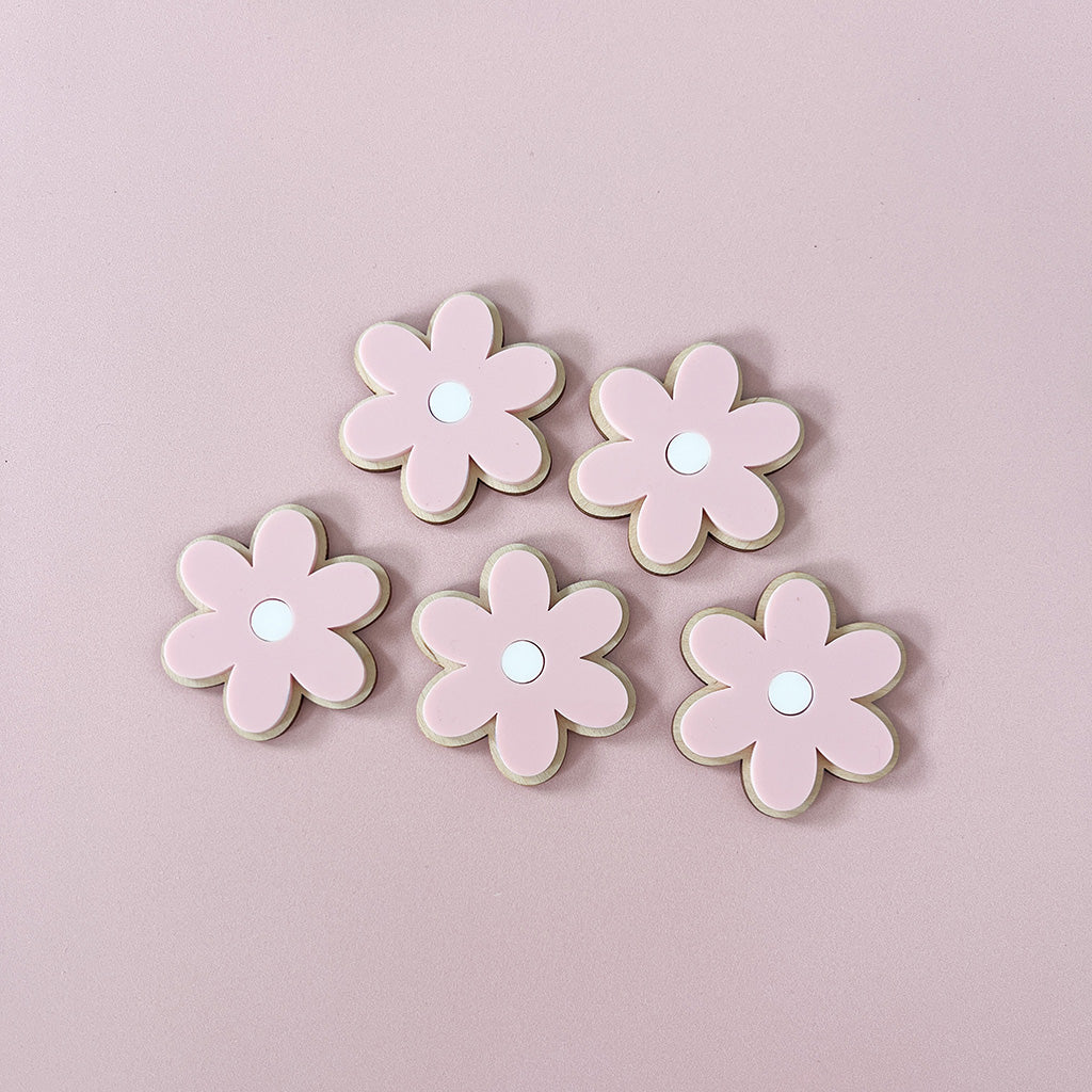 Pink acrylic flowers layered onto natural wood for children's wall decor