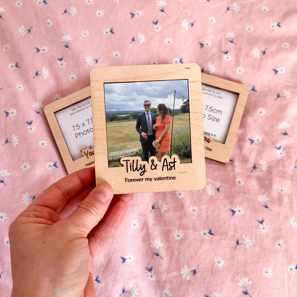 Wooden photo frame with a couple's picture on a pink floral background