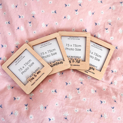 Four wooden photo frames on a pink floral background