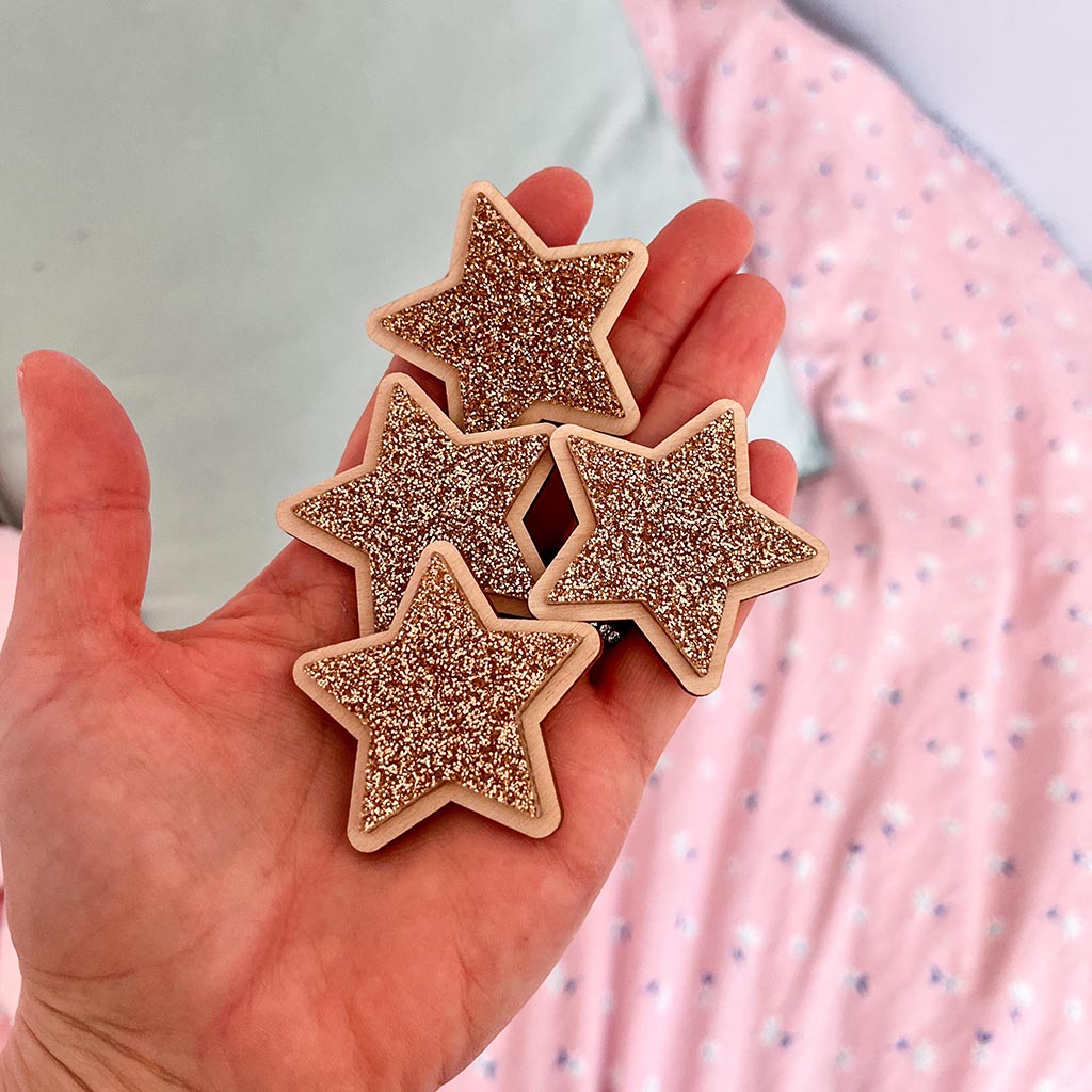 Gold glitter stars layered onto wood and arranged as nursery wall decor