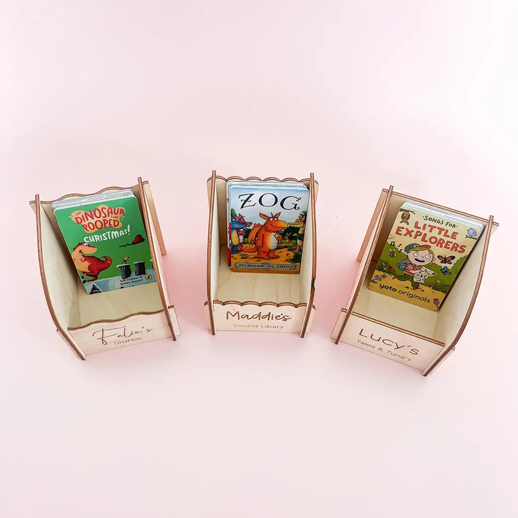 Three personalised wooden Yoto card holders with engraved names and children’s audio cards